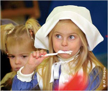 Una niña disfrazada de colona inglesa (Pilgrim) disfruta la comida en el centro infantil Montessori de Wheeling, Virginia Occidental