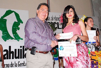 El alcalde Alberto Aguirre Villarreal, entrega reconocimiento a la ganadora del desfile de modas Da vida al Planeta. ¡Recicla!