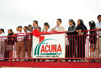 El alcalde de Acuña Alberto Aguirre y alumnos de la primaria La Misión dan el corte de listón inaugural del puente peatonal.