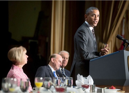   El presidente Obama ante un atril; detrás de él, personas sentadas (White House)