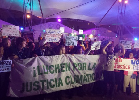 Mientras los gobiernos de 195 países aprobaban el documento final de la COP 20, en Lima la madrugada del 14 de diciembre, los activista protestaban ya por los débiles resultados de las negociaciones climáticas, a las afueras del salón Cusco de la plenaria, donde se pactó el acuerdo. Crédito: Diego Arguedas Ortiz/IPS