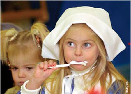 Una niña disfrazada de colona inglesa (Pilgrim) disfruta la comida en el centro infantil Montessori de Wheeling, Virginia Occidental