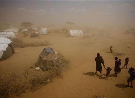 Los refugiados somalíes caminar a través de una tormenta de polvo en un campamento cerca de la ciudad de Dadaab. Una crisis de empeoramiento de la sequía amenaza a 10 millones de personas en el Cuerno de África. foto UNICEF